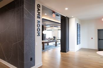A hallway with a Game Room sign on the wall at The Crest at South Point Apartments, Georgia